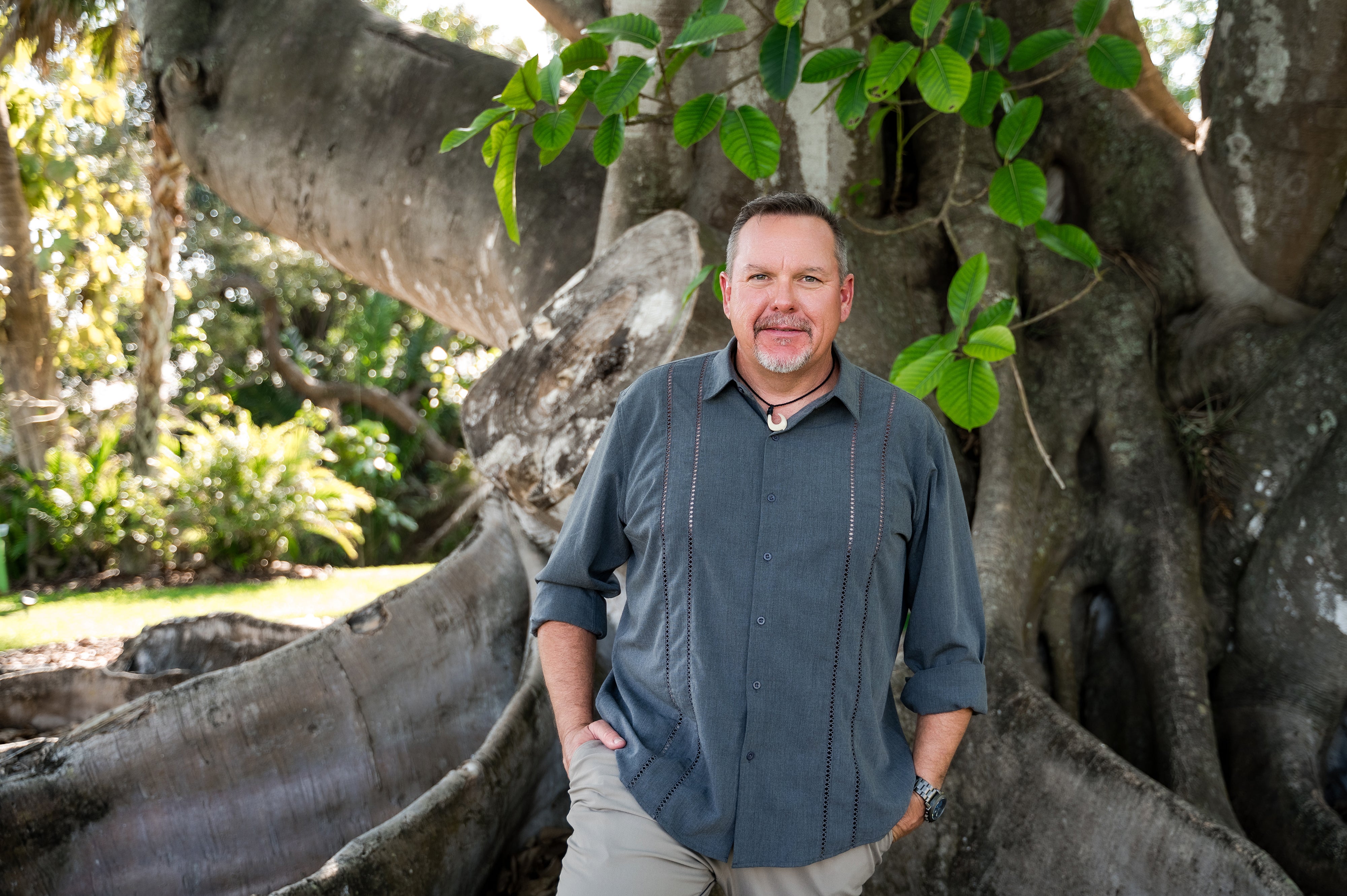 A man standing in front of a large tree